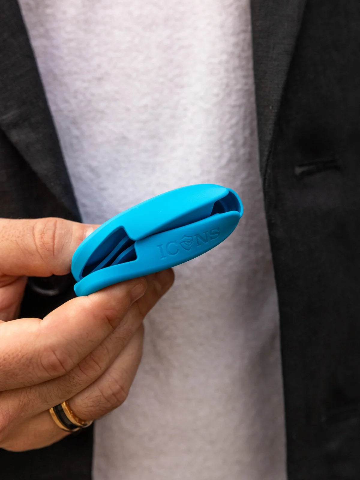Blue Icons case held folded between two fingers